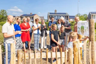 Vier kinderen van de school onthullen het bord.